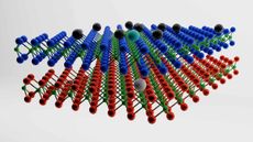 two layers of a chemical structure lie above each other with black balls hovering on top. On the top layer, there is a cyan ball with a white ball in the corresponding layer below