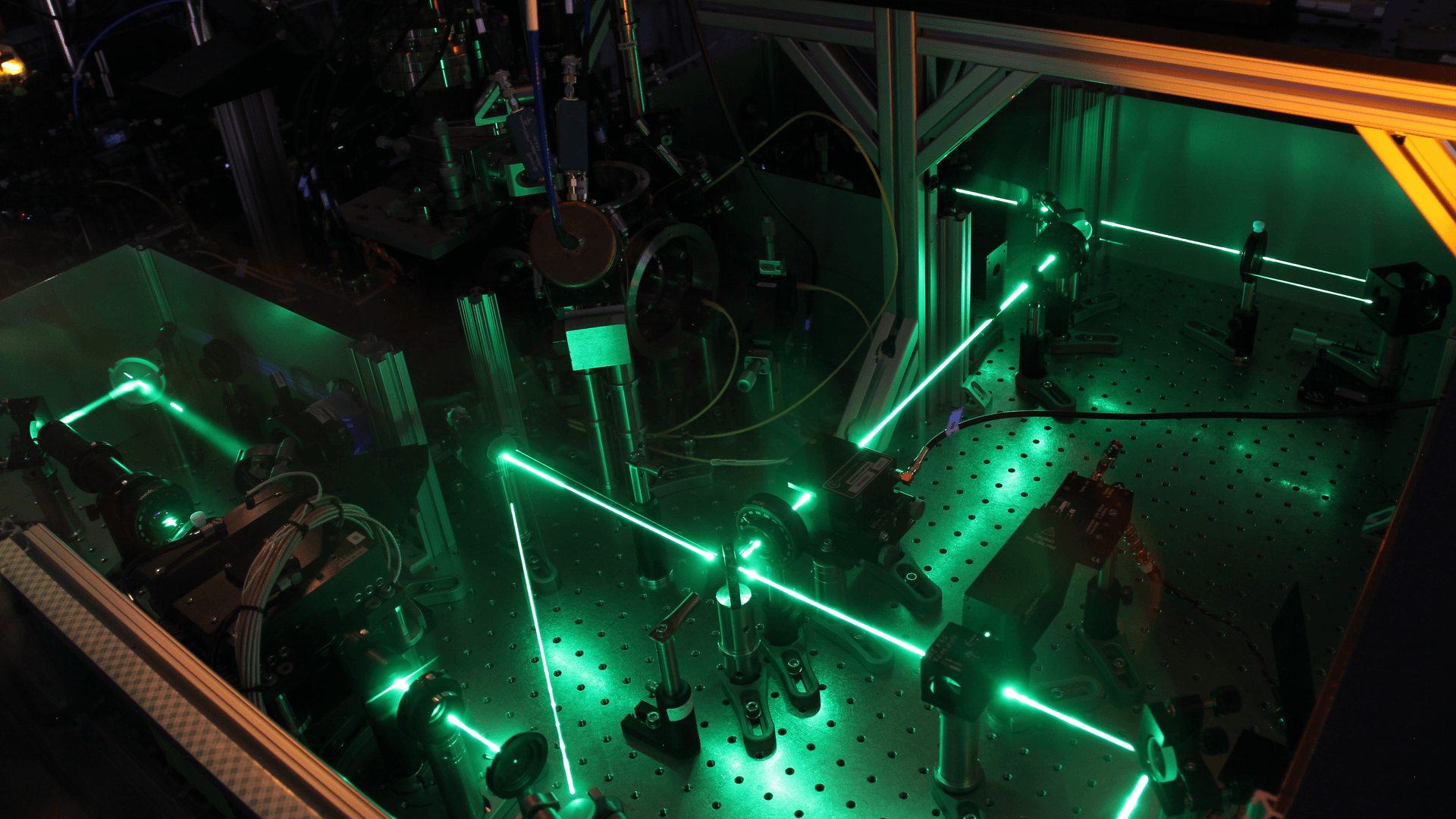 a photo of an optics bench with green laser beams